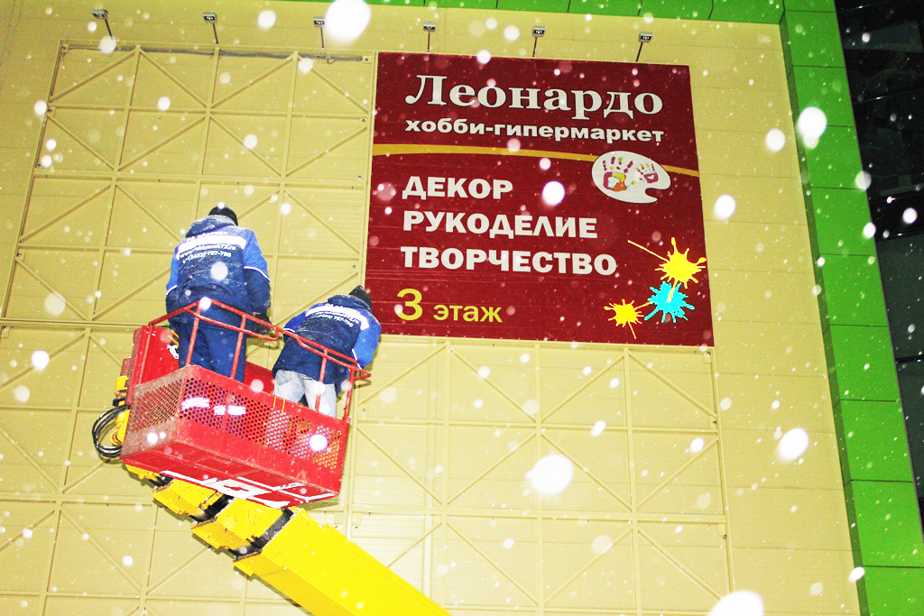 Монтаж баннера Леонардо на фасад ТРЦ Вояж в Тобольске